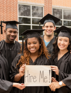 Photo of grads holding hire me sign
