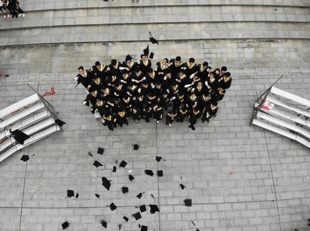 an aerial view of Grad students tossing graduation caps